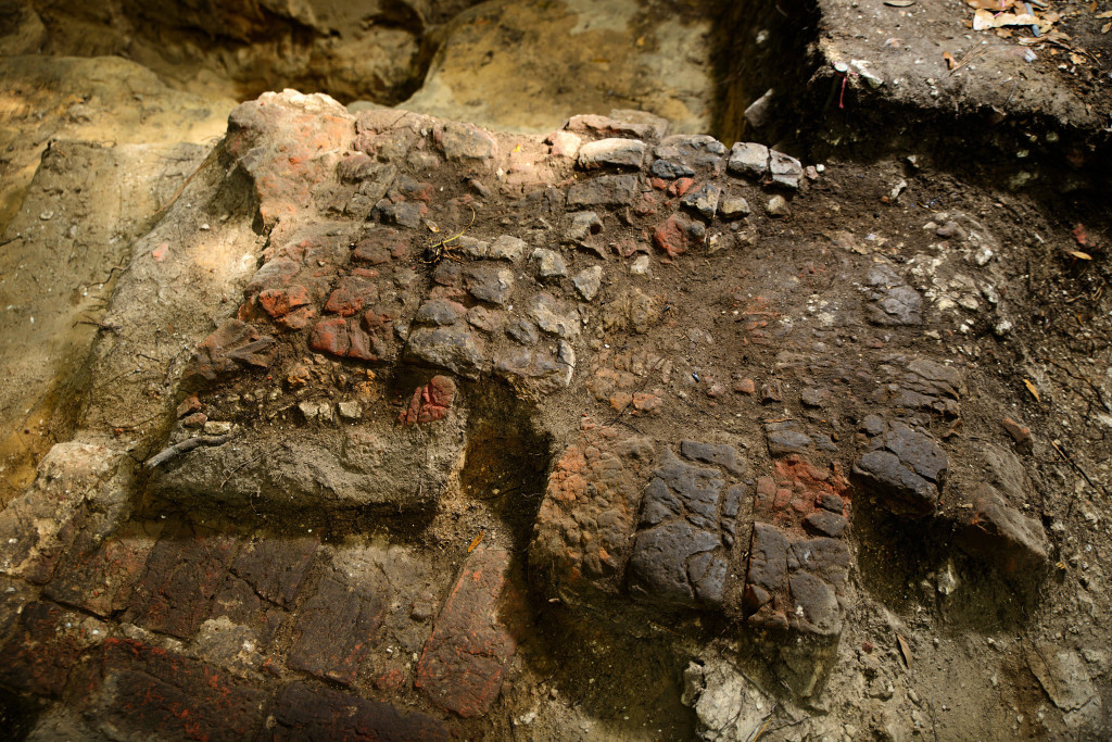 Archaeologists uncovered an intact 1670s brick wall foundation (bottom left) is overlaid by intact brick fireplace hearth (center) at the Miller site. Credit: Patrick Hall